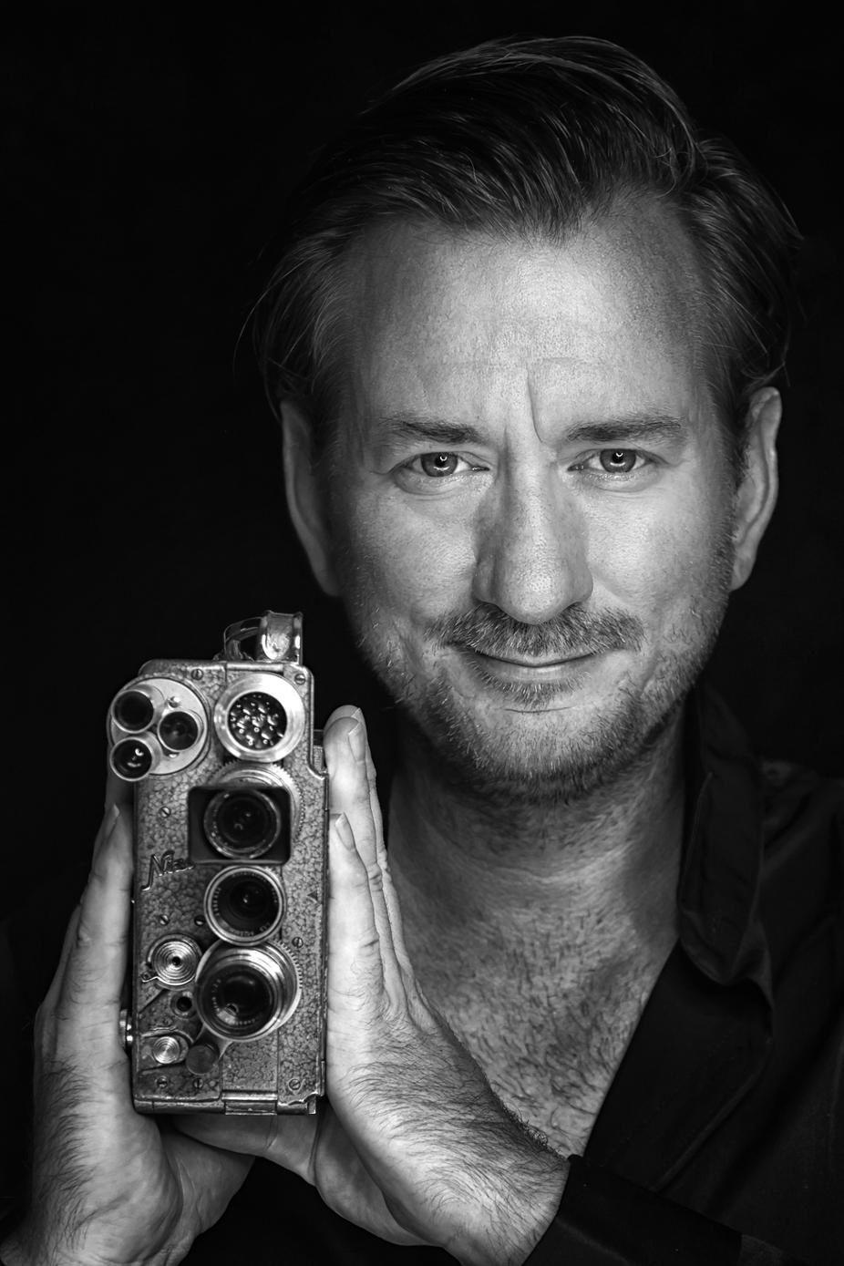 Porträt von Jan E. Siebert mit einer historischen Filmkamera